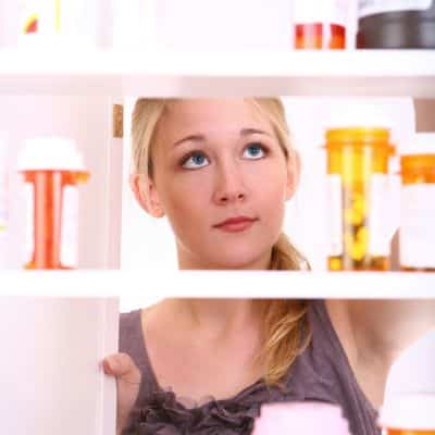 Girl looking into medicine cabinet