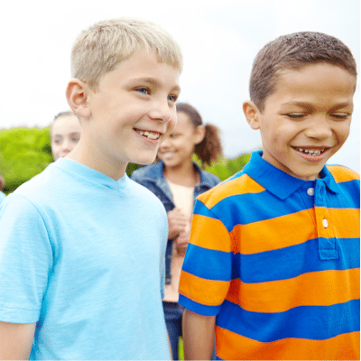 A group of children smiling and talking, representing social skills development in children